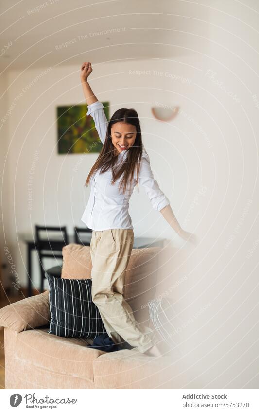 Fröhliche junge Frau tanzt allein zu Hause Tanzen heimwärts Freude heiter Fröhlichkeit Freiheit Wohnzimmer hell Genuss Erwachsener Freizeit Aktivität
