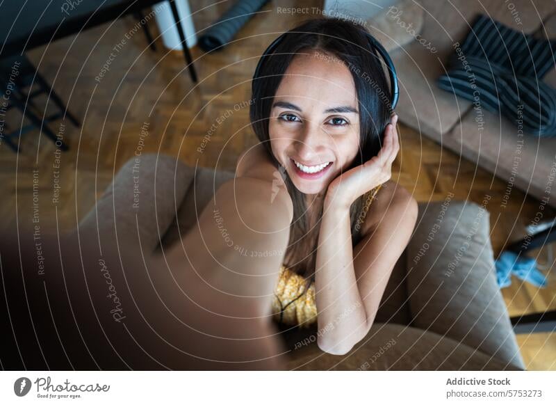 Lächelnde junge Frau macht ein Selfie mit Kopfhörern zu Hause heimwärts heiter Innenbereich Freizeit Lifestyle Glück lässig Fotografie Erholung Musik