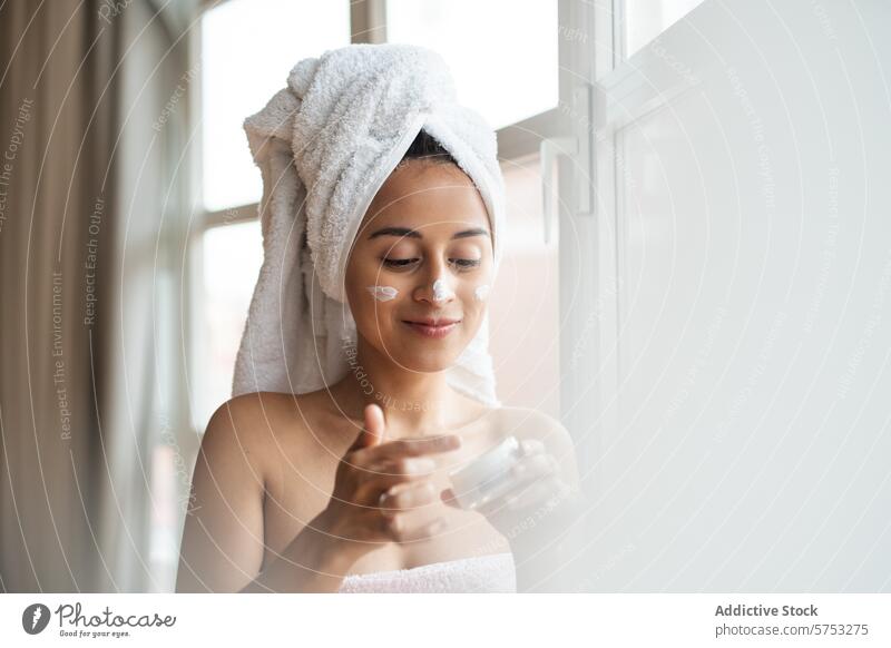 morgendliche Hautpflege mit Feuchtigkeitscreme Frau Gesichtsbehandlung Sahne Schönheit Regime täglich Routine Handtuch Behaarung eingewickelt Dusche