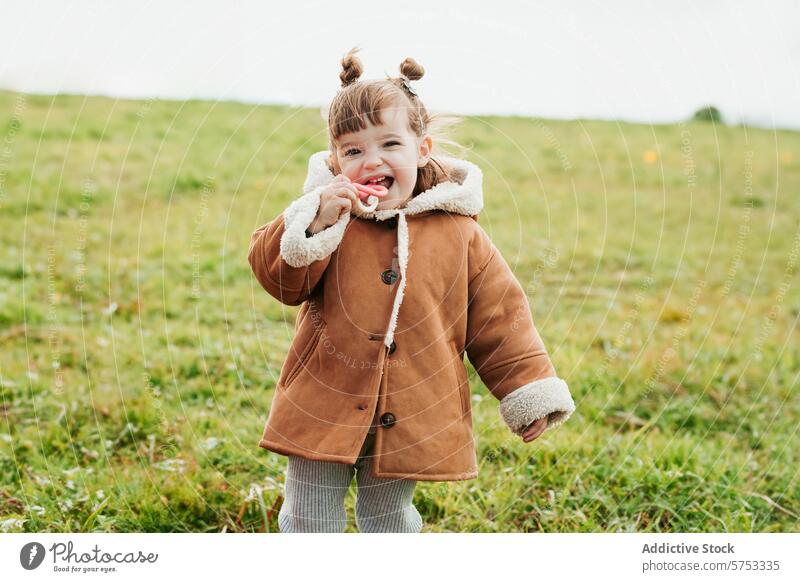 Fröhliche Kleinkind Mädchen im Mantel Spielen im Freien im Feld Kind spielen Lächeln heiter niedlich warm Herbst Natur Lifestyle lässig Fröhlichkeit Freude jung