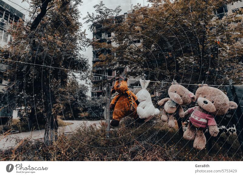 Kinderspielzeug hängt an einem Seil vor dem Hintergrund der zerstörten und verbrannten Häuser in der Ukraine donezk Kherson kyiv Lugansk mariupol Russland