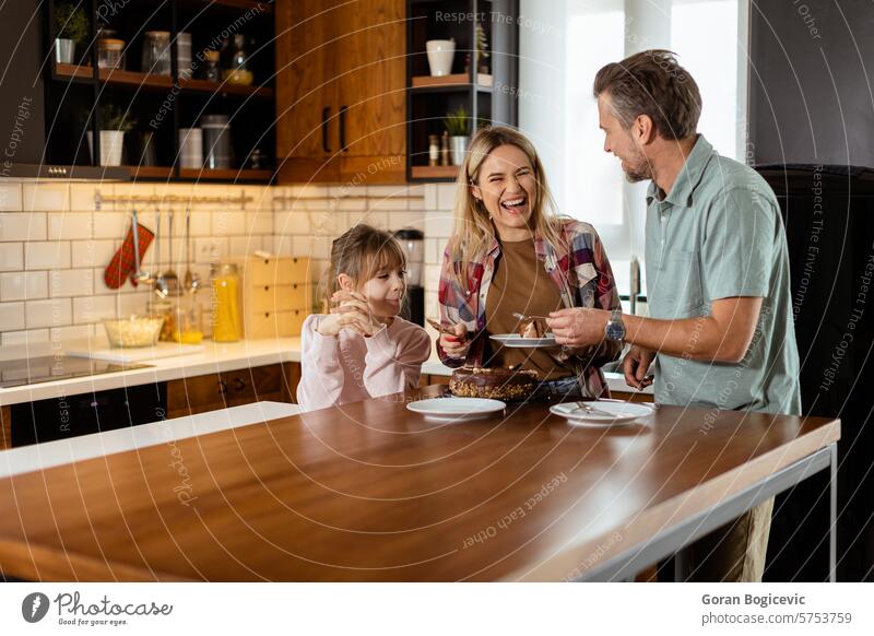 Fröhliche Familie genießt hausgemachten Schokoladenkuchen in gemütlicher Küche selbstgemacht genießend Dessert Bonden Lächeln lachen sonnenbeschienen Essenszeit