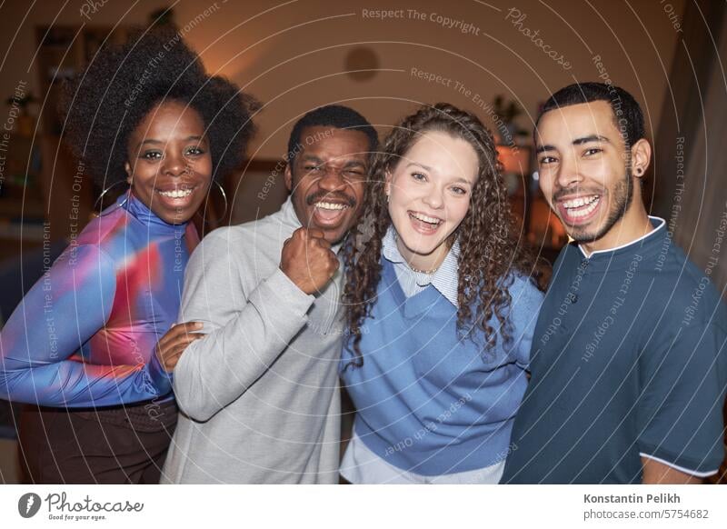 Diverse Gruppe fröhlicher erwachsener Freunde schaut in die Kamera und lächelt während einer Hausparty mit Blitzlicht Party heimwärts Menschengruppe Vielfalt
