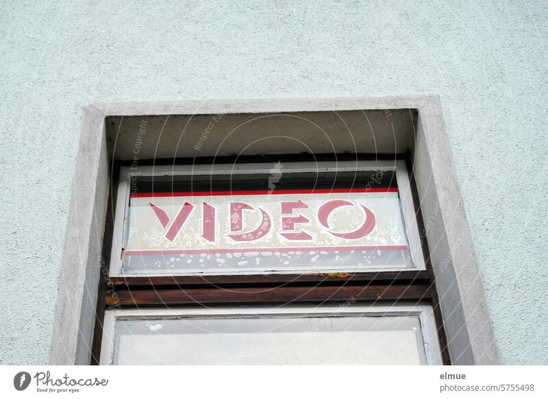 blaue Hausfassade mit Fenster und dem Schriftzug VIDEO hinter der Glasscheibe Video Nostalgie Videothek videre Videoverleih retro Vergangenheit Videoclip
