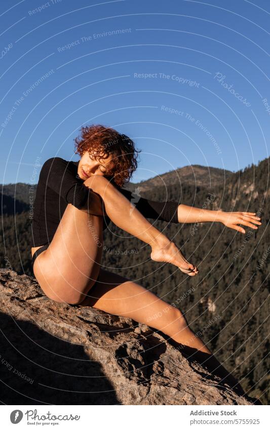 Anmutige Tänzerin posiert auf einem felsigen Berg bei Sonnenuntergang Zeitgenosse Pose Berge u. Gebirge Eleganz Blauer Himmel Künstlerin künstlerisch