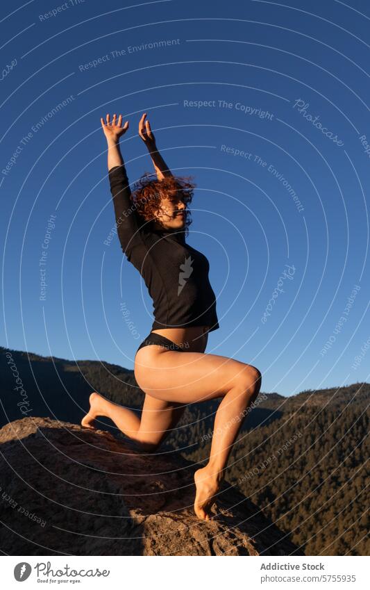 Anmutige Tänzerin posiert auf einem Berg in der Abenddämmerung Zeitgenosse Berge u. Gebirge Pose Freiheit Ausdruck jung Blauer Himmel im Freien Frau