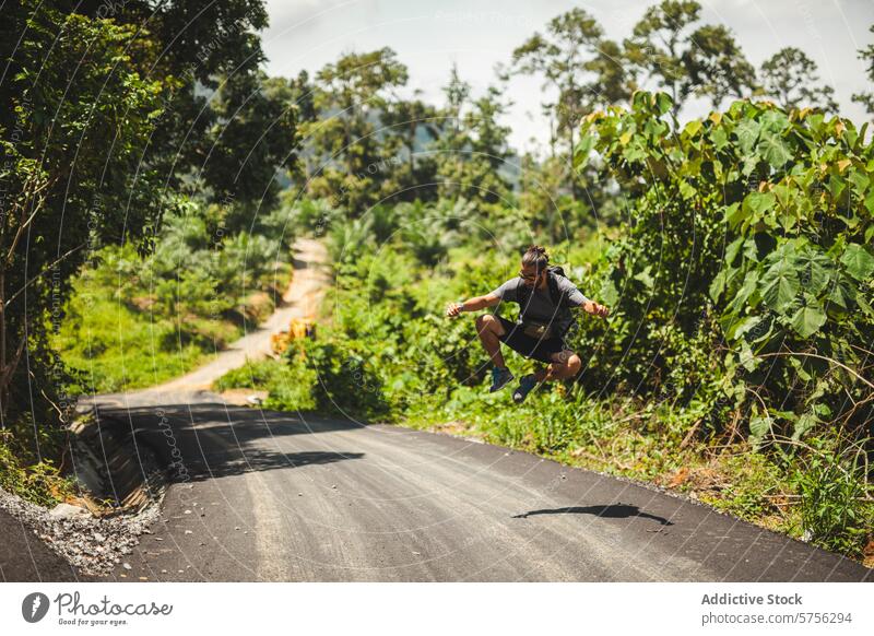 Abenteuerlicher Sprung über eine malerische indonesische Straße Reisender springen Freude ländlich tropisch Wald Indonesien üppig (Wuchs) Landschaft Natur