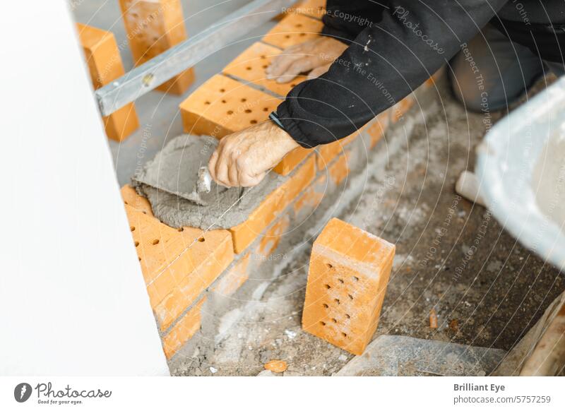 Handwerker, der die Ziegelwand mit Beton und Kelle beschichtet Baustein Spachtel Belag Wand Job Messung Arbeit Industrie Konstruktion Maurerarbeiten Mauerwerk
