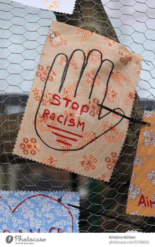 stop racism rassismus stopp aufhören stoppen beenden schluß halt abwehren bekämpfen hand stoff forderung aufforderung bitte hoffnung zaun stoffmuster