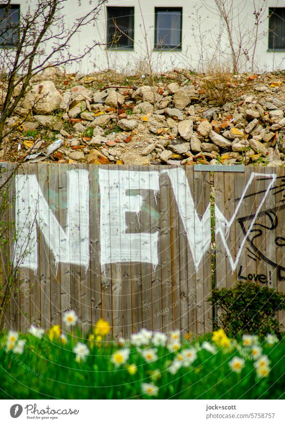 NEW - Neubau, Schuttberg, Bauzaun und Frühlingsblumen neu Straßenkunst Spray Graffiti Wand Englisch Schutthaufen Schriftzeichen Wort Typographie Großbuchstabe