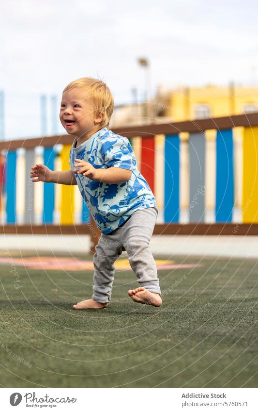 Fröhlicher Moment auf dem Spielplatz mit der Familie Baby Down-Syndrom Spielen Freude Kleinkind farbenfroh Fröhlichkeit Barfuß Kind im Freien Erholung Aktivität