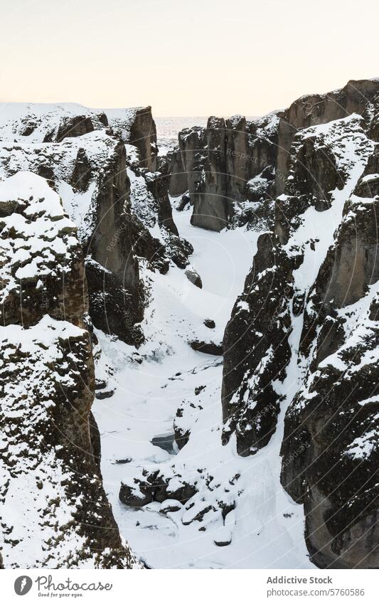Eine Winteransicht der Fjadrargljufur-Schlucht in Island, bei der der Schnee die zerklüfteten Konturen der alten Felsen hervorhebt fjadrargljufur Klippe robust