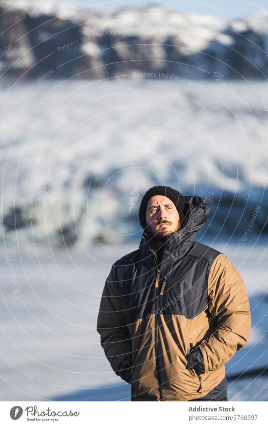 Ein Abenteurer in warmer Winterkleidung blickt nachdenklich auf die weite Gletscherlandschaft, die sich im Herzen Islands entfaltet Entdecker Mann glazial