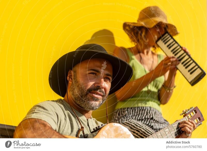 Straßenmusiker spielen in einer lebhaften städtischen Umgebung Musik duo Künstlerin Mann Frau Gitarre Keyboard urban Stadt Leistung Musiker gelb Hintergrund