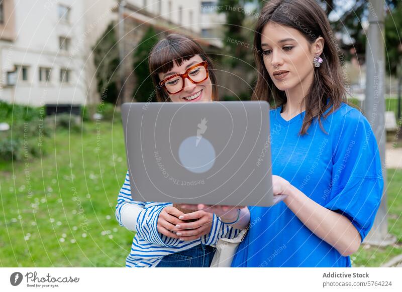 Frühjahrsmode und Technologie: Frauen nutzen Laptop im Freien Frühling Technik & Technologie Park Mode lässig Freundschaft Internet digital Gerät Mobile