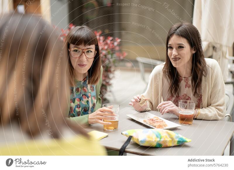Freunde genießen ein frühlingshaftes Mittagessen im Freien Frau Gespräch trinken Snack lässig Frühling Freundschaft Glück Lächeln Mode Stil Brille Erwachsener