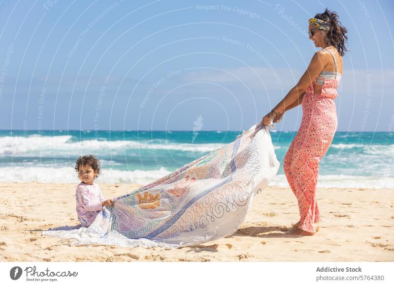 Mutter und Kind spielen mit Stoff am sonnigen Strand Familie Frau Gewebe Sand MEER Brise Sommer im Freien Freizeit Spaß Bonden Tochter Kleinkind Meer Küste