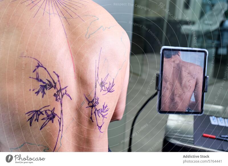 Tätowierer skizziert Design auf dem Rücken eines unkenntlichen Kunden Tattoo Künstler Frau skizzierend männlich Klient Atelier professionell Tablette Bild