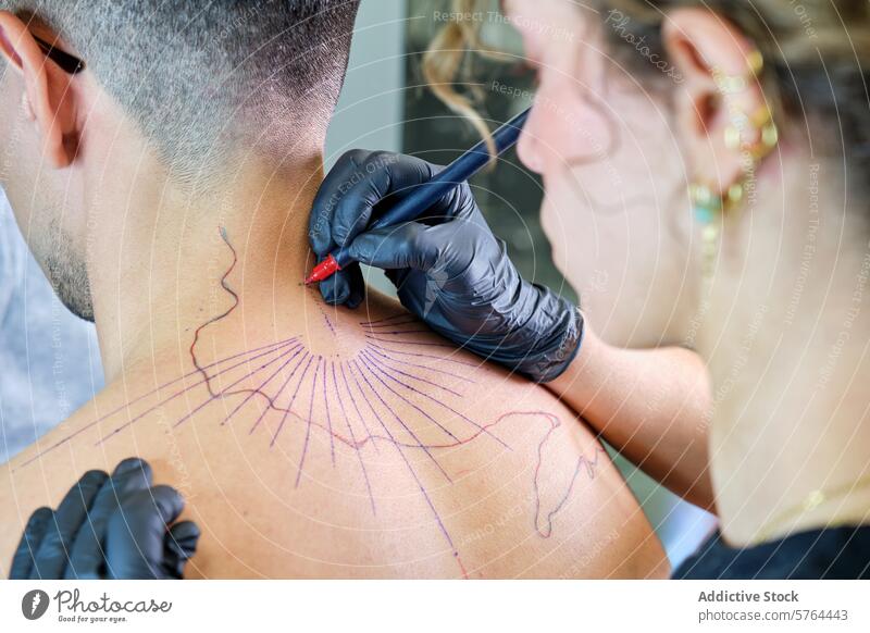 Tätowierer bei der Arbeit im Studio an einem männlichen Kunden Tattoo Künstler Frau Mann Atelier Tätowierung Klient Rücken Zeichnung Linien professionell Tusche