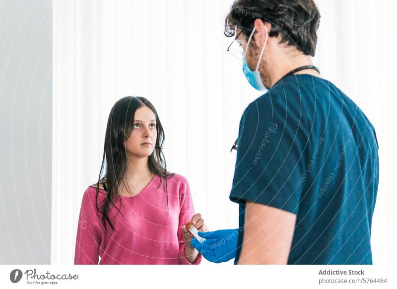 Eine medizinische Fachkraft in blauem Kittel bereitet konzentriert ein medizinisches Gerät vor, während der Patient mit vertrauensvollem Blick zusieht