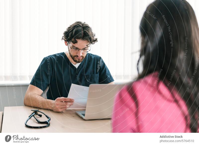 Ein Arzt prüft während eines Patiententermins aufmerksam die Unterlagen und zeigt, dass er bei der Behandlung seiner Patienten sehr sorgfältig vorgeht