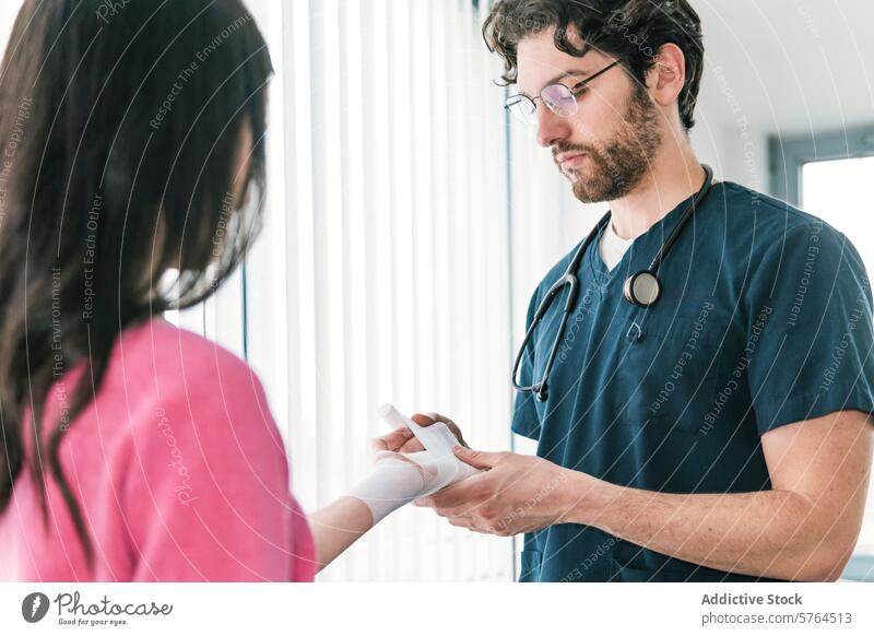 Fokussiertes Bild einer medizinischen Fachkraft, die einen Verband am Handgelenk eines Patienten anlegt, um die richtige Wundversorgung sicherzustellen