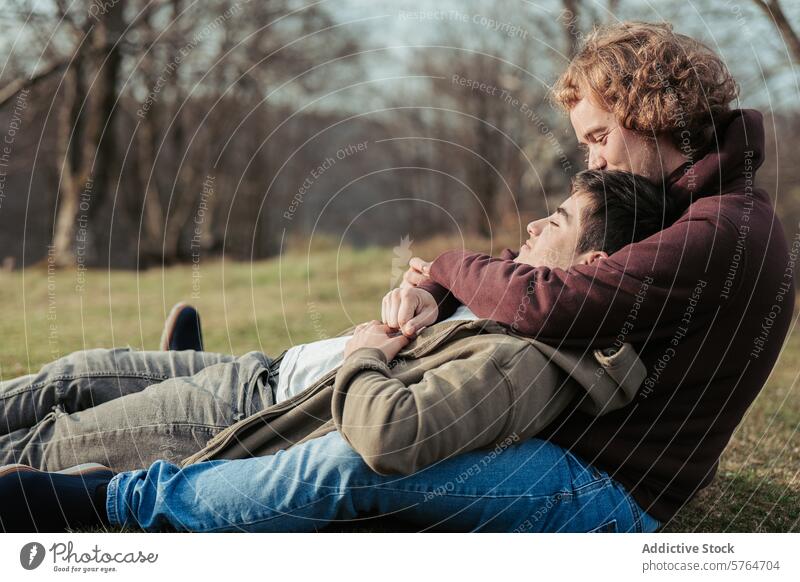 Ein schwules Paar entspannt sich in den Armen des anderen und genießt einen ruhigen Moment der Intimität und des Komforts auf einer weichen Wiese unter freiem Himmel