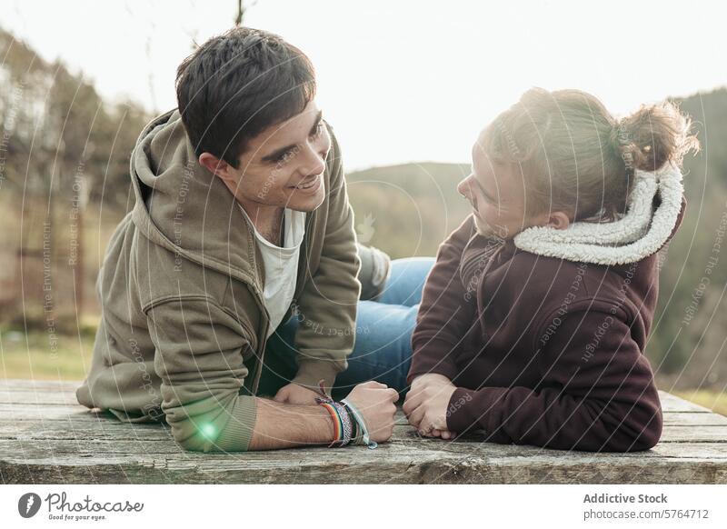 Ein schwules Paar genießt einen Moment der Verbundenheit und des unbeschwerten Gesprächs, während es draußen vor der Kulisse der ruhigen Natur sitzt engagiert