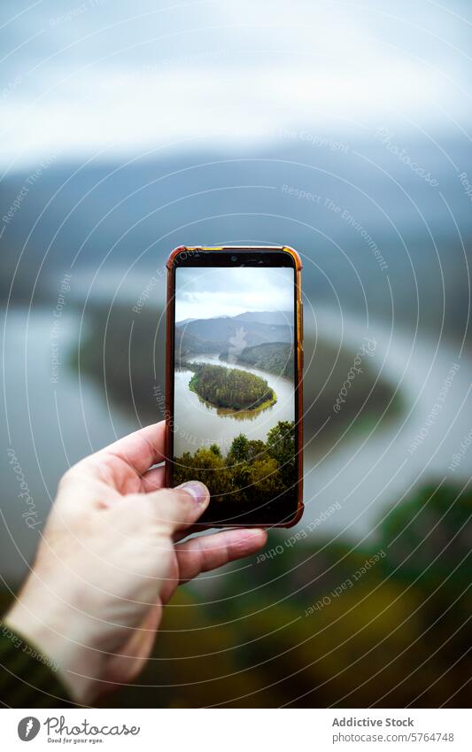 Aufnahme eines Flusslaufs durch einen Smartphone-Bildschirm Irrfahrt Hand Bäume Nebel Rahmung malerisch Natur Landschaft Flussbiegung im Freien Beteiligung