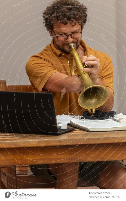 Ein einarmiger Trompeter spielt und komponiert Musik Composing kreativ Prozess heimwärts Hof Laptop Mann männlich Musiker Opferbereitschaft Laken Konzentration