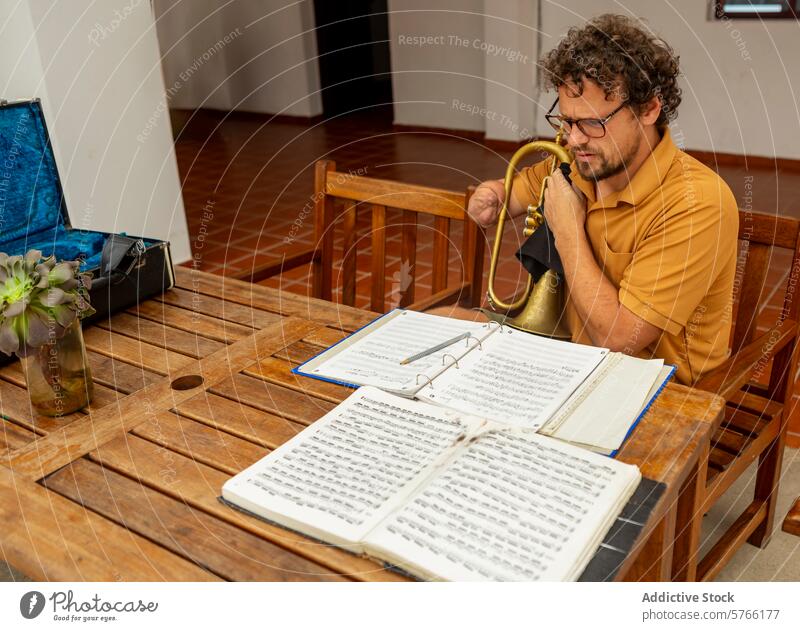 Einarmiger Trompeter studiert Musik zu Hause einarmig üben Mann männlich Hof heimwärts kreativ Prozess Reflexion & Spiegelung lernen Instrument Notenblatt
