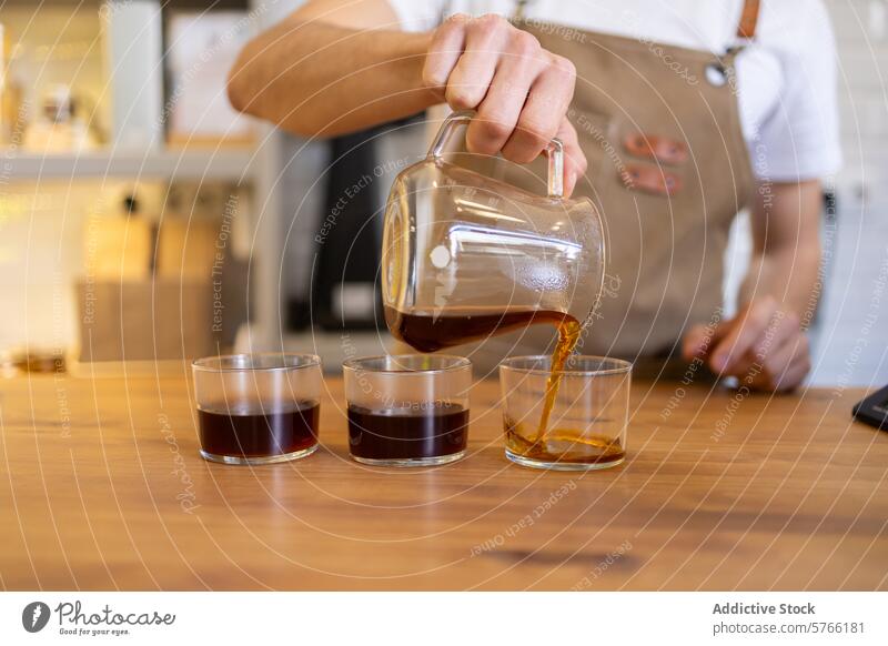 Barista gießt frischen Kaffee in Tassen auf einem Holztisch Gießen hölzern Tisch übersichtlich Karaffen Dämpfen Café trinken Getränk Glas Brauen Servieren
