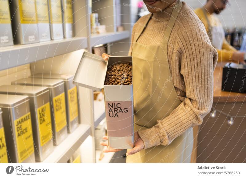 Der Barista hält eine Kiste mit Kaffeebohnen aus Nicaragua Schürze gebraten nicaraguanisch Bohnen Werkstatt Kasten gemütlich Präsentation Einzelhandel