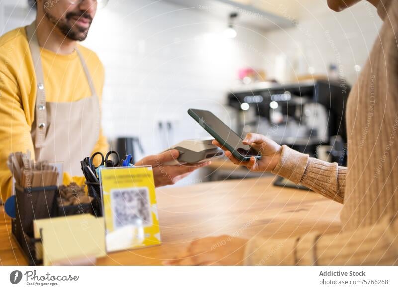 Kunde beim mobilen Bezahlen in einem modernen Cafe mobile Bezahlung Café Barista berührungslos Smartphone Kasse freundlich Technik & Technologie Transaktion