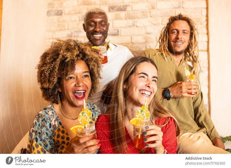 Fröhliche Freunde lachen und schlürfen Cocktails in einer gemütlichen Bar Freundschaft Spaß Freude Menschengruppe Getränk sozialisierend Vielfalt Glück Party