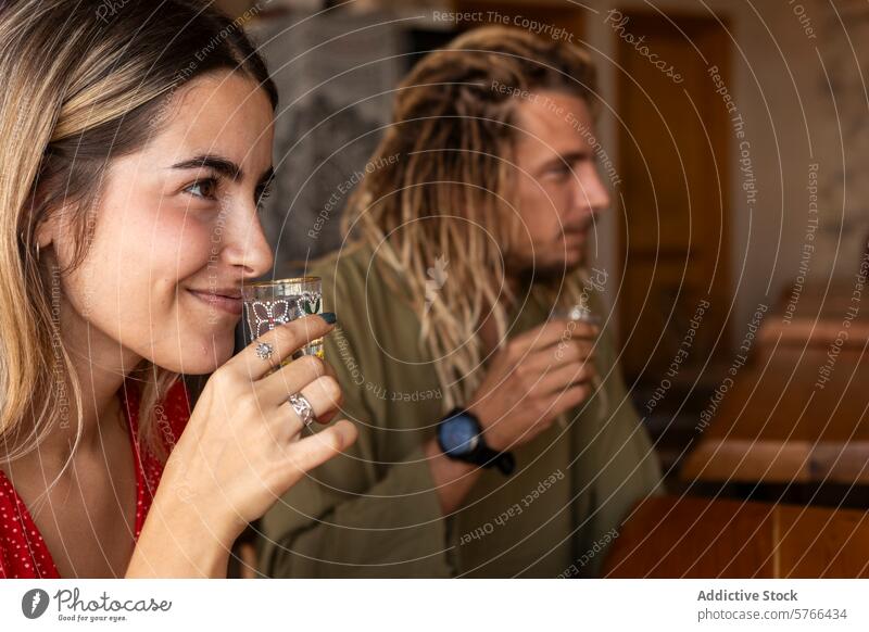 Ein subtiles Lächeln und gemeinsame Drinks in einer gemütlichen Bar-Atmosphäre Frau Mann Schnapsglas trinken Verkostung entspannt Gemütlichkeit Freunde Genuss