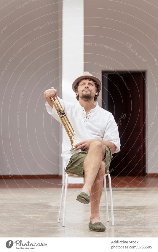 Einarmiger Mann mit Trompete, sitzend in einem Haus einarmig Sitzen Stuhl im Innenbereich Tatkraft Fokus Musikinstrument Messing üben heimwärts Musiker Hobby