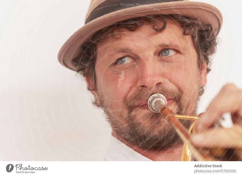 Entschlossener Musiker, der Trompete übt Trompeter einarmig üben heimwärts Leidenschaft Durchhaltevermögen Talent Instrument Hut Tatkraft Hobby Mann Erwachsener