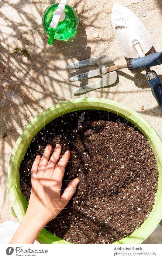 Vorbereiten der Erde in einem Gartentopf für die Bepflanzung Gartenarbeit Boden Hand Topf Blumenerde reicher Boden Werkzeuge Gießkanne grün Vorbereitung