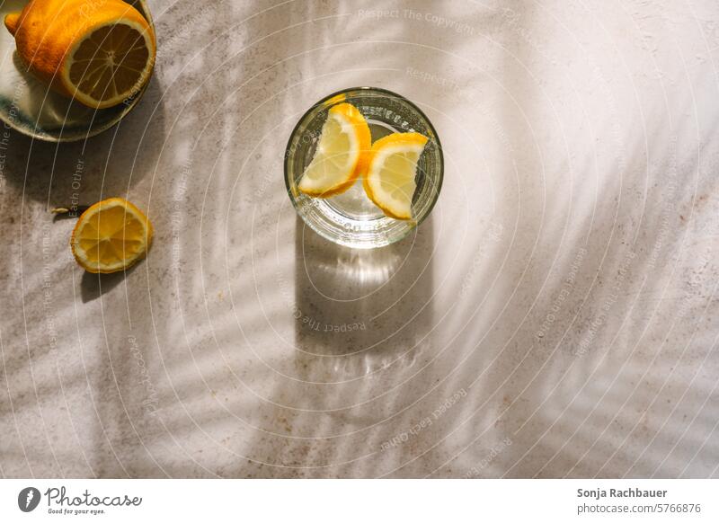 Ein Wasserglas mit Zitrone Getränk Trinkwasser Erfrischungsgetränk Farbfoto Draufsicht Lichtspiel Gesundheit Durst trinken kalt Flüssigkeit Durstlöscher
