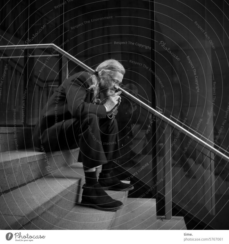 nachdenklicher Mann auf einer Treppe sitzen Glasfassade Anzug grauhaarig nachdenken Blick nach unten Porträt Ganzkörperaufnahme Profil langhaarig Handlauf