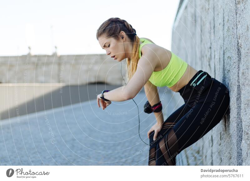 fröhliche Frau, die sich nach dem Sport, Laufen und Training ausruht. Fitness strecken aussruhen Übung jung Gesundheit hören Musik passen im Freien schön