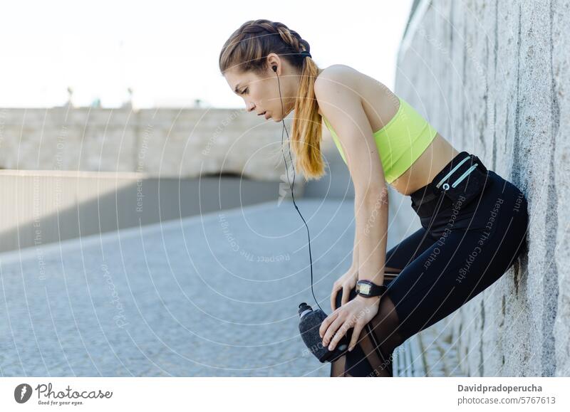 fröhliche Frau, die sich nach dem Sport, Laufen und Training ausruht. Fitness strecken aussruhen Übung jung Gesundheit hören Musik passen im Freien schön