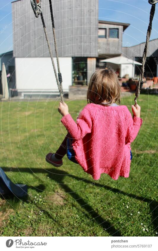 ein kleines Kind schaukelt im Garten schaukeln kind kindheit freude garten pink frühling sonnig Spielen Bewegung Lebensfreude Freizeit & Hobby Außenaufnahme