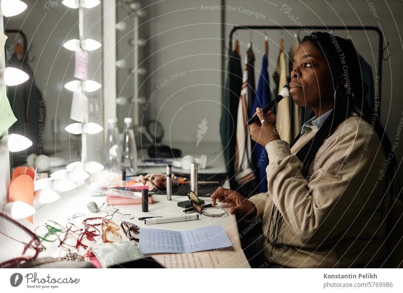 Seitenansicht Porträt der afroamerikanischen Frau macht Make-up von Spiegel in der Garderobe immer bereit für die Leistung Kopie Raum zusammenstellen erröten