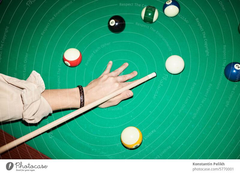 Nahaufnahme eines nicht erkennbaren Mannes, der an einem grünen Billardtisch mit Kamerablitz Billard spielt. Pool abschließen Hand männlich spielen Spiel Halt