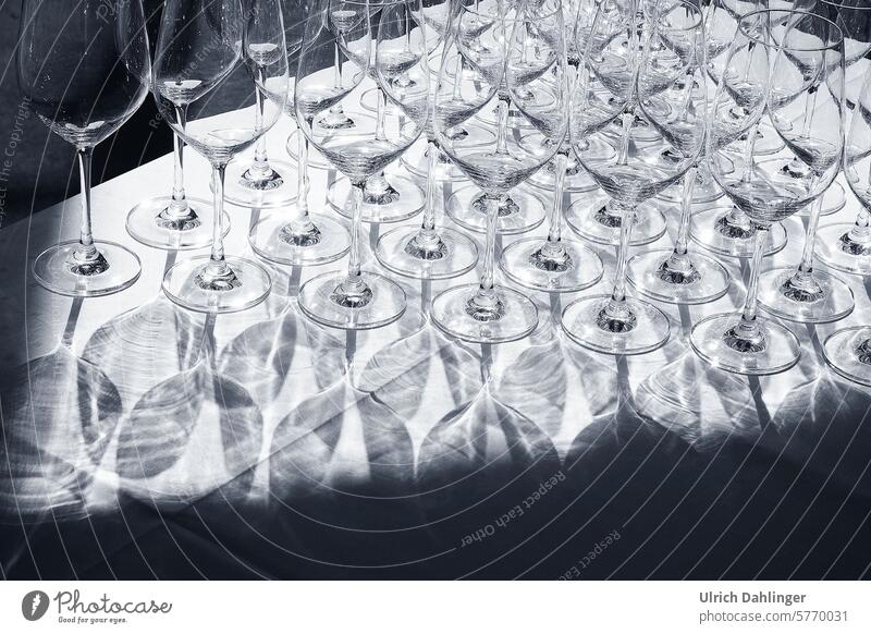 viele Weingläser auf weißer Tischdecke mit Schattenwurf Glas Gastronomie abstract Muster Licht ungewöhnliche Form