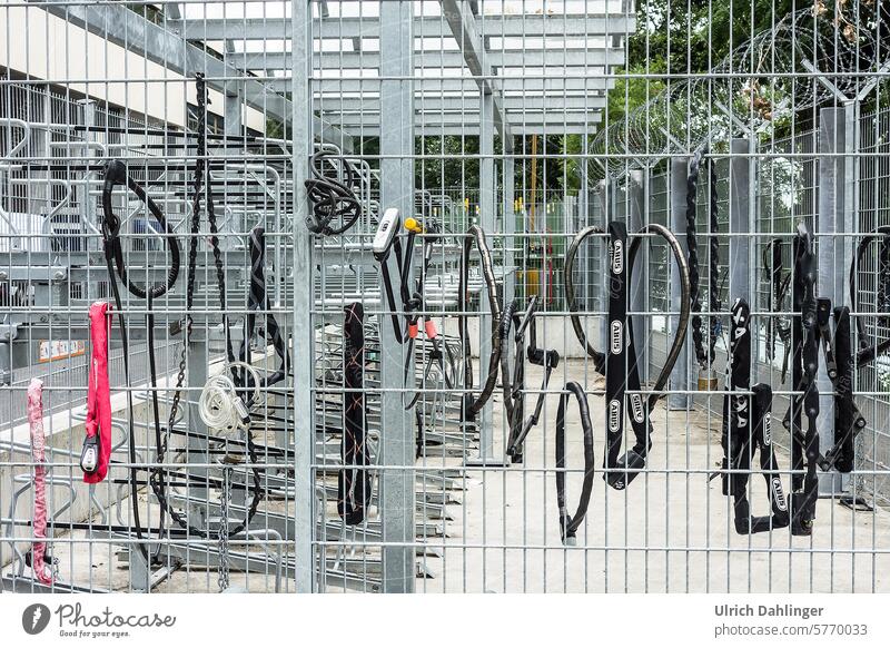 Verschiedene Fahrradschlösser an einem Sicherheitszaun eines Fahrradabstellplatzes Fahrradschloß Diebstahl Schutz Diebstahlschutz
