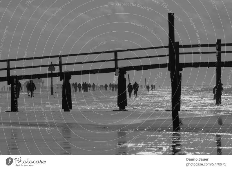 Menschen laufen am Strand entlang. Pier Spaziergang Landschaft Wasser Küste Meer Tourismus Pfahlbau Seebrücke Nordsee