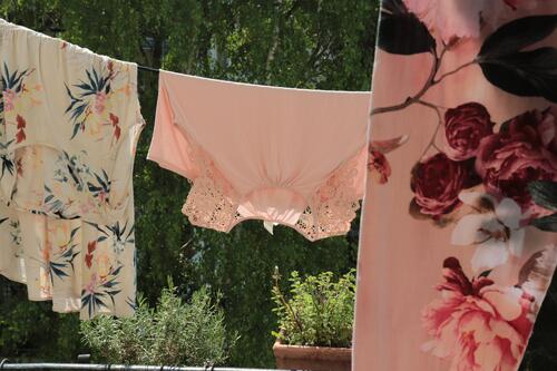 blumige Wäsche auf einer Wäscheleine Balkon Kräuter Kräutertöpfe trocknen Wäsche waschen Häusliches Leben Waschtag romantisch weiblich Kleidung Luft luftig